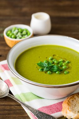 Yeşil bezelye çorbası kase ahşap tablo