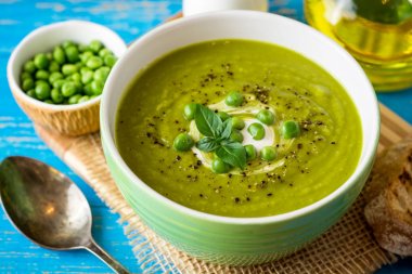 Yeşil bezelye çorbası kase ahşap tablo