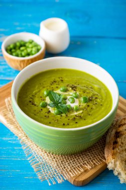 Yeşil bezelye çorbası kase ahşap tablo