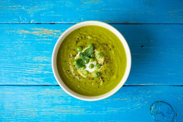 Yeşil bezelye çorbası kase ahşap tablo