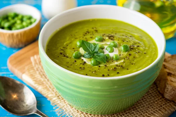 Yeşil bezelye çorbası kase ahşap tablo