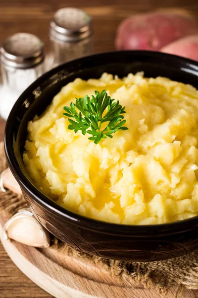 Purée de pommes de terre au beurre et persil frais dans un bol sur une table en bois rustique — Photo
