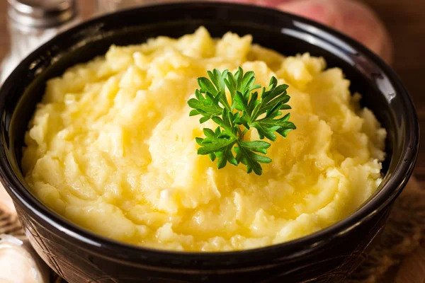 Purée de pommes de terre au beurre et persil frais dans un bol sur une table en bois rustique — Photo