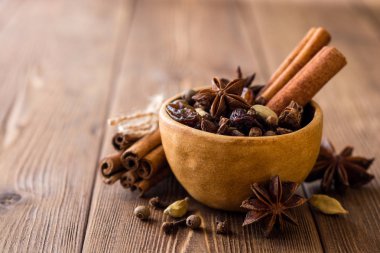 Baharat için mulled şarap seramik kase üzerinde ahşap masa ayarla.