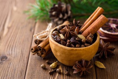 Baharat için mulled şarap seramik kase üzerinde ahşap masa ayarla.