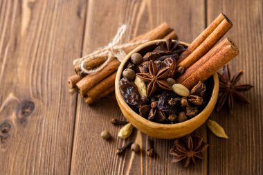 Baharat için mulled şarap seramik kase üzerinde ahşap masa ayarla.