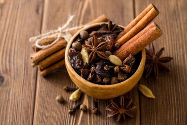 Baharat için mulled şarap seramik kase üzerinde ahşap masa ayarla.
