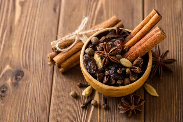 Baharat için mulled şarap seramik kase üzerinde ahşap masa ayarla.