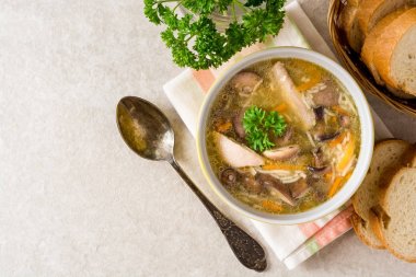 Mantar ve erişte gri taş zemin üzerine bir kapta tavuk çorbası