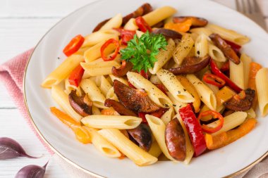 Mantar, biber, biber ve maydanoz Beyaz ahşap zemin üzerinde beyaz tabakta Penne makarna.