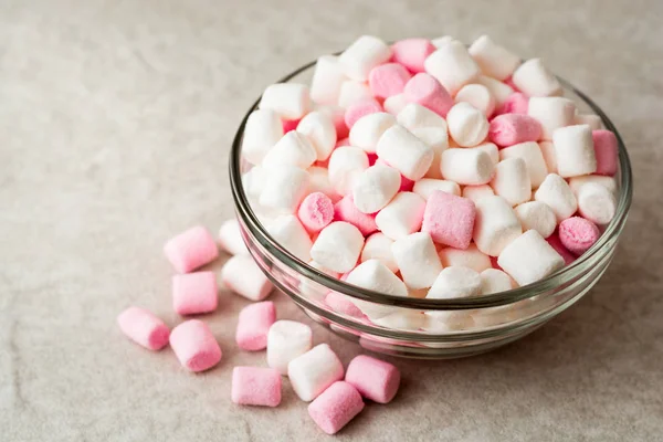 White and pink mini marshmallows in glass bowl on stone background. — Stock Photo, Image