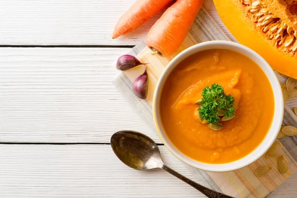 Κολοκύθι και καρότο σούπα με σπόρους κολοκύθας και μαϊντανό σε μπολ σε άσπρο φόντο ξύλινη κρέμα. — Φωτογραφία Αρχείου