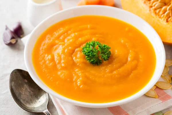 Κολοκύθι και καρότο σούπα με μαϊντανό σε γκρι πέτρα φόντο κρέμα. — Φωτογραφία Αρχείου