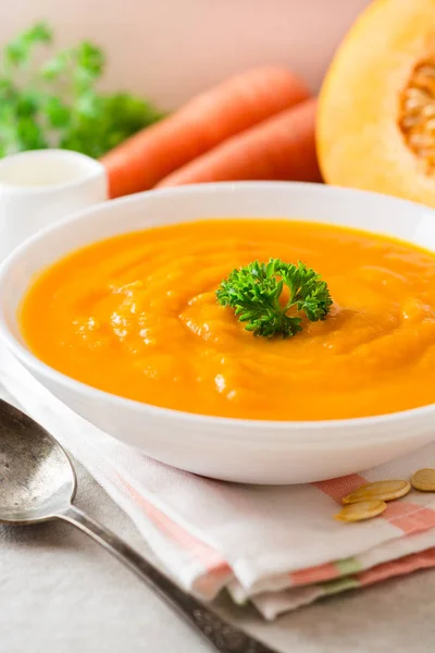 Sopa de crema de calabaza y zanahoria con perejil sobre fondo de piedra gris . —  Fotos de Stock