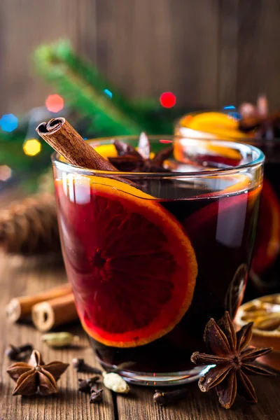 Two glasses of christmas mulled wine with oranges and spices on wooden background. — Stock Photo, Image