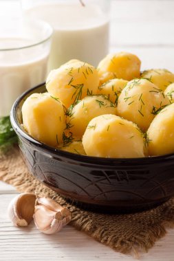 Beyaz ahşap zemin ıslak zeminde dereotu ile haşlanmış patates.