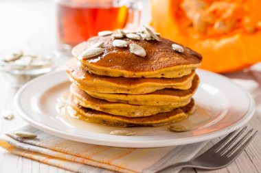 Bal ve plaka Beyaz ahşap zemin üzerinde kabak çekirdeği ile kabak krep.