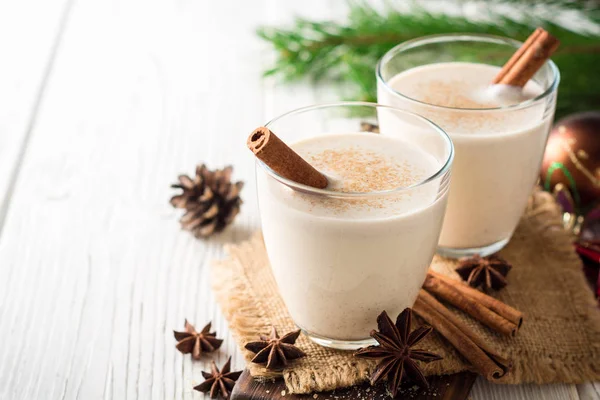 Hemmagjord äggtoddy med riven muskot och kanel på vita träbord. Traditionell jul dryck. — Stockfoto