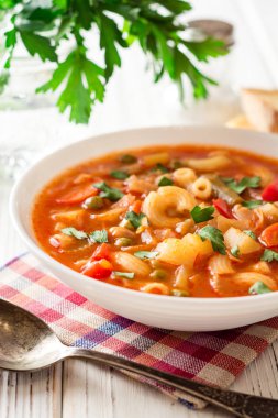 Beyaz ahşap zemin üzerinde İtalyan sebzeli çorba çorba.