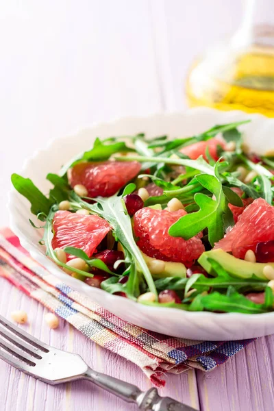 Salată proaspătă cu arugula, grapefruit, avocado, semințe de rodie și nuci de pin . — Fotografie, imagine de stoc