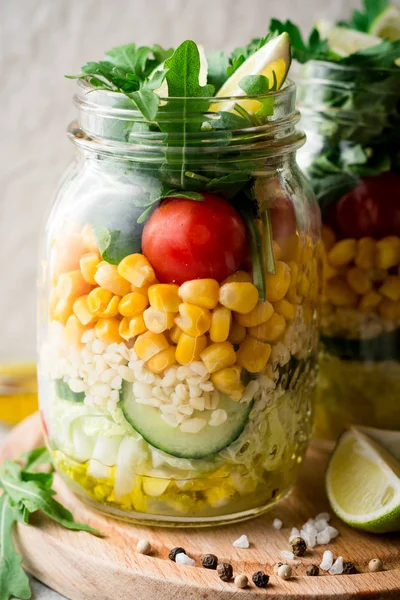 Ensaladas caseras saludables con bulgur, verduras y lima en frascos de albañil sobre fondo de piedra gris . — Foto de Stock