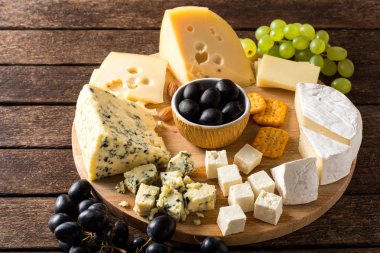 ahşap kesme tahtası üzerinde peynir türleri.