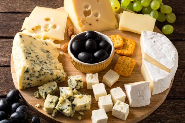 ahşap kesme tahtası üzerinde peynir türleri.