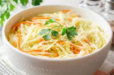 Gri taş zemin üzerine kase taze lahana salatası.