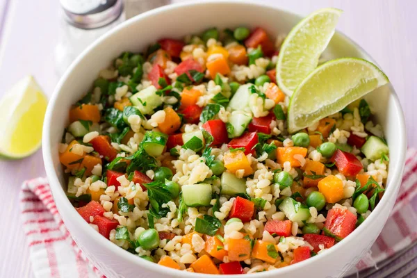 Ensalada fresca con bulgur y verduras en tazón sobre mesa de madera — Foto de Stock