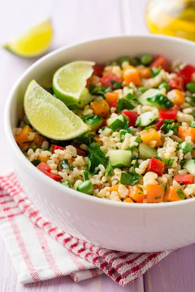 Ensalada fresca con bulgur y verduras en tazón sobre mesa de madera — Foto de Stock