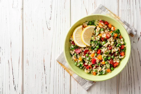 Ensalada fresca con bulgur y verduras sobre mesa de madera blanca — Foto de Stock