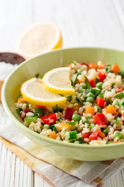 Ensalada fresca con bulgur y verduras sobre mesa de madera blanca — Foto de Stock