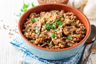 Buğday lapası mantar Beyaz ahşap zemin üzerinde bir kase ile