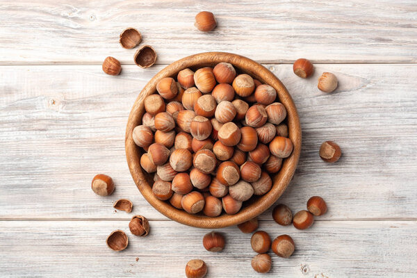 Орехи в миске на белом деревянном фоне. Вид сверху
.