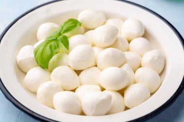 Mini mozzarella peyniri mavi beton arka planda demir tabakta. Seçici odak.