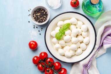 Mini mozzarella peyniri mavi beton arka planda demir tabakta.