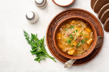 Geleneksel Rus lahana çorbası. Beton arka planda seramik kasede şalgam çorbası.