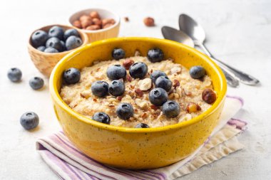 Fındıklı yulaf lapası ve beton arka planda yaban mersini kasesi. Seçici odak.