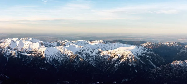 Panorama aéreo de montanhas nevadas no por do sol — Fotografia de Stock