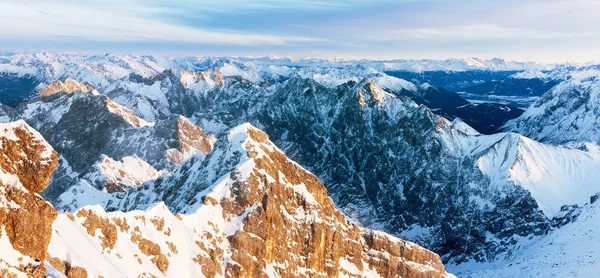 Panorama aéreo de montanhas rochosas nevadas ao pôr do sol — Fotografia de Stock