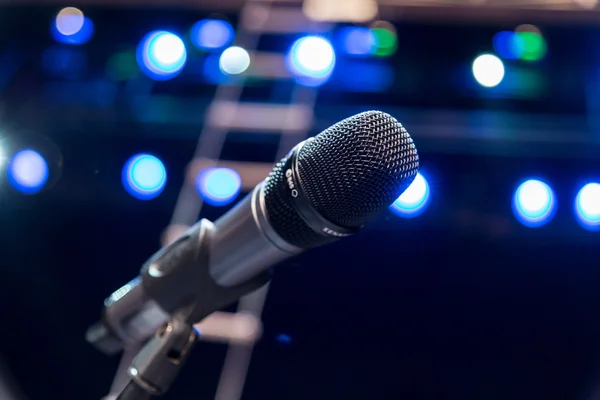 Microfone sem fio no palco, luzes embaçadas no fundo — Fotografia de Stock