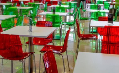 Boş tablolar, bir kafede yeşil ve kırmızı sandalyeler