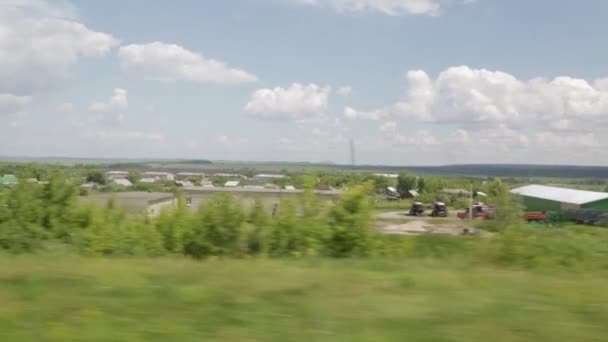 Asentamiento en la provincia rusa. Filmando desde la ventana de un tren en movimiento. Día de verano — Vídeo de stock