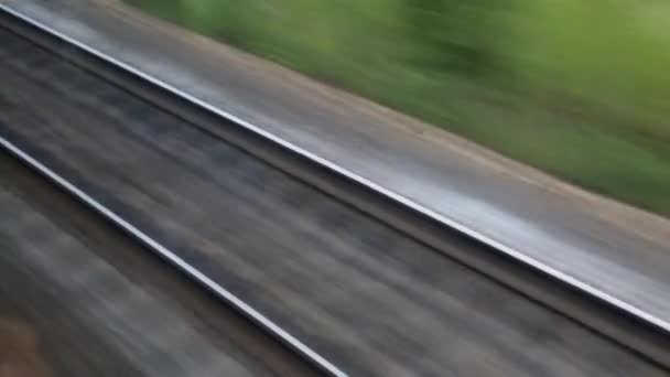 Le voyage en train. Tourné par la fenêtre d'un train en mouvement, voies ferrées, rails, traverses .