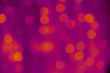 Sarı ve mor arka plan bulanık. Festival çelenk bulanıklık, bokeh içinde. Renkli ışıklar bulanıklık