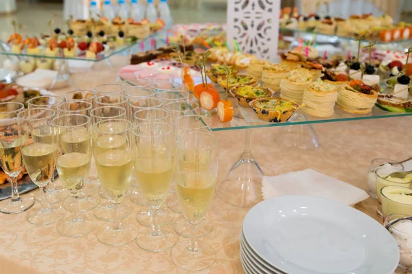Banquet table with snacks, delicacies, beverages and desserts. On-site service. Catering