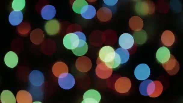 Sfondo sfocato astratto colorato. Ghirlanda di Natale colorata. Bokeh e sfocatura della lente — Video Stock