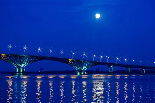 Noite ou paisagem noturna. A lua estava cheia. Ponte rodoviária através do rio Volga em Saratov, Rússia . — Fotografia de Stock