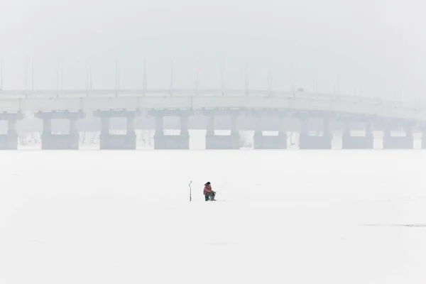 Pesca de inverno no gelo. O rio Volga em Saratov, Rússia. Ponte rodoviária no horizonte — Fotografia de Stock