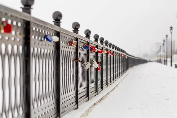 Zámky lásky a věrnosti na kovový plot. Město Saratov, Rusko. Nábřeží řeky Volhy. Zimní — Stock fotografie
